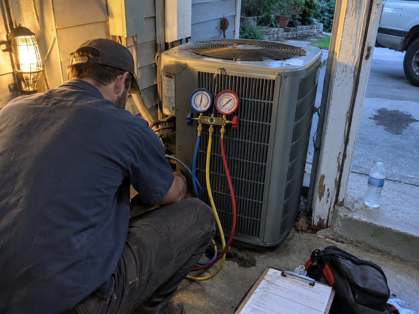 Refrigerant gauge check on an outdoor AC condenser by 7th Degree Heating and Air