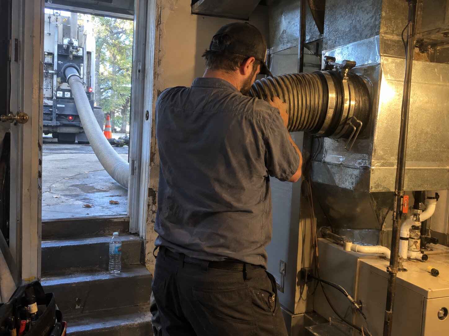 Truck-mount HEPA duct cleaning attached to a plenum by 7th Degree Heating and Air